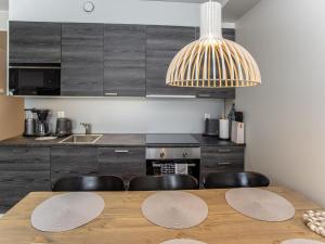 a kitchen with a wooden table and black cabinets at Holiday Home Levistar vi as- 6106 by Interhome in Levi