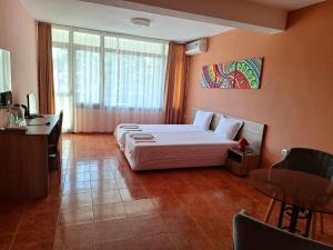 a bedroom with a large bed in a room with a table at Guest House Starata Kushta in Lozenets