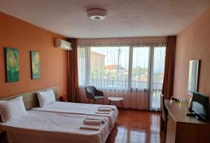 a hotel room with a bed and a large window at Guest House Starata Kushta in Lozenets
