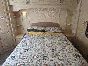 a bed with two pillows in a small room at 34 Glenfinart Park in Dunoon