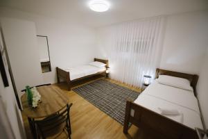 a room with a bed and a table with a tableablish at Apartman Fidelis in Ljubuški