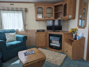 a living room with a tv and a couch and a table at 34 Glenfinart Park in Dunoon