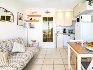 a living room with a couch and a kitchen at Apartment Cap Océan-8 by Interhome in Mimizan +29 photos