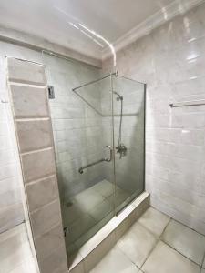 a shower with a glass door in a bathroom at Topaz Pearl Exquisite Apartments in Lekki