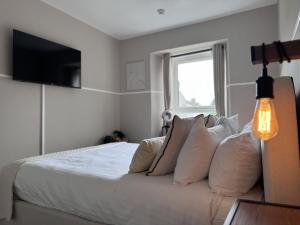 a bedroom with a bed with white sheets and pillows at Glendevon Hotel in Auchterarder