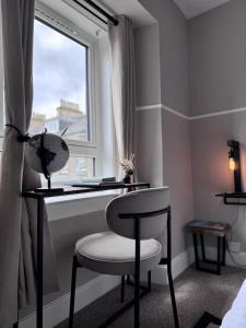 a room with a desk and a chair and a window at The Glendevon Hotel in Auchterarder
