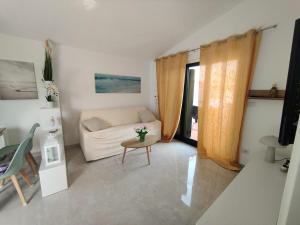 a living room with a couch and a table at Apartment - Sleeps 4 - Pool - Parking in SantʼAndrea Apostolo dello Ionio +5 photos