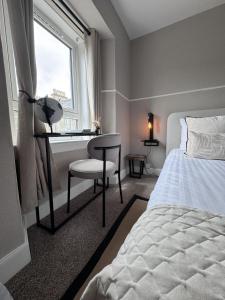a bedroom with a bed and a desk and a window at The Glendevon Hotel in Auchterarder