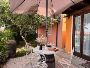 a table and chairs under an umbrella on a patio at B&B La Baita "monolocale ad uso esclusivo" in Fonni