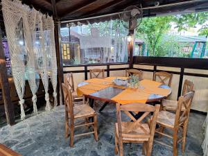 a wooden table and chairs in a room at Guest House Starata Kushta in Lozenets