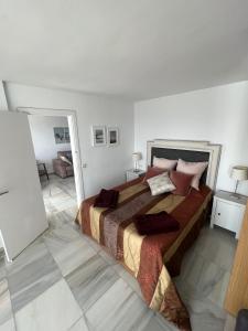 a bedroom with a large bed in a white room at Home Relax Calypso in Sitio de Calahonda +27 photos
