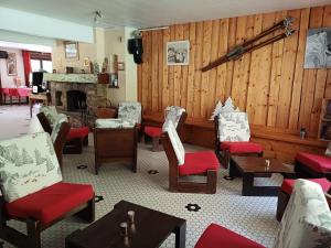 a room with chairs and tables and a fireplace at Hotel et centre de vacances Le Choucas in Sixt