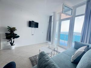 a living room with a blue couch and a large window at Villa Mare Blu in Sozopol