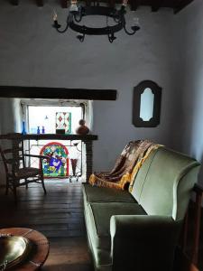 a living room with a green couch and a table at Gîte Dűrer in Fanjeaux