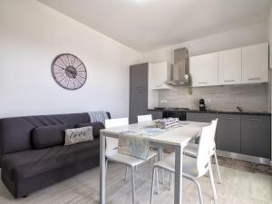 Una cocina y una sala de estar con mesa y sillas. en Apartment Alta Marea by Interhome, en Valledoria