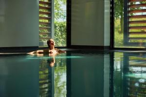 une femme se baignant dans une piscine dans une maison dans l'établissement Van der Valk Hotel Breukelen, à Breukelen