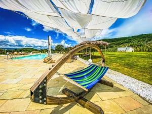 a hammock on a patio next to a pool at Villa Il Sogno Di Pietro by Interhome in Fondaccio