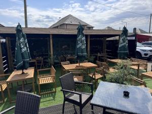 an outdoor patio with tables and chairs and umbrellas at The Glendevon Hotel in Auchterarder