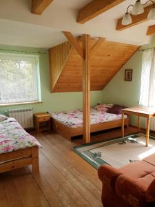 a bedroom with two beds and a loft at Gosidomek in Zawoja