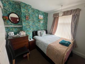 a bedroom with a bed and a dresser and a mirror at The Northdale Hotel Ltd in Skegness