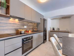 a kitchen with white cabinets and a stove top oven at Holiday Home Villa Marija by Interhome in Marčana
