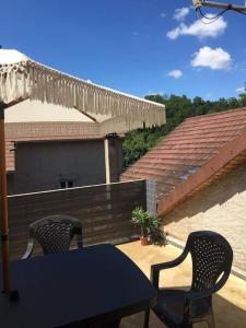 a patio with two chairs and a table and an umbrella at Mesnay, belle maison spacieuse in Mesnay +4 photos