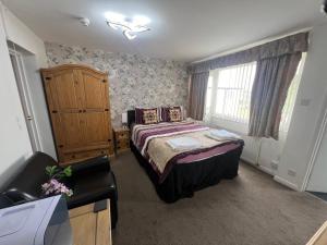 a bedroom with a bed and a dresser and a window at The Northdale Hotel Ltd in Skegness
