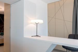 lampa na białym blacie w pokoju w obiekcie Boutiquehotel Wörthersee - Serviced Apartments w mieście Velden am Wörthersee
