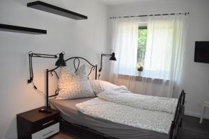 a bedroom with a bed with white sheets and a window at Haus Kanalliebe in Nübbel