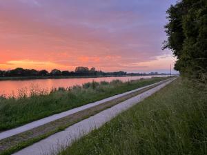 a dirt road next to a body of water at Haus Kanalliebe in Nübbel
