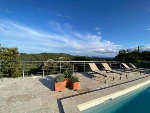 balcone con sedie a sdraio e piscina di LIS ESTELLO - Gîte à FLAYOSC VAR a Flayosc