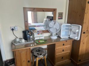 a room with a desk with a fan and a mirror at The Northdale Hotel Ltd in Skegness