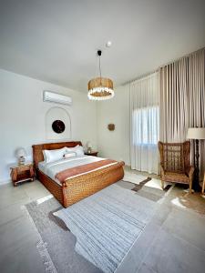 a bedroom with a large bed and a large window at Acacia Sifah in Muscat +19 photos
