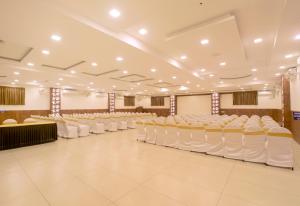 a large room with rows of white chairs at Manjhi Residency in Tiruchchirāppalli