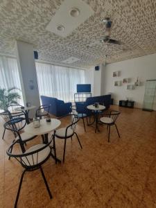 a room with tables and chairs in a room at Hotel Kursaal in Bellaria-Igea Marina