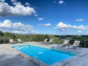 una piscina su un patio con sedie a sdraio e vista di LIS ESTELLO - Gîte à FLAYOSC VAR a Flayosc