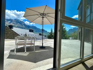 a table with an umbrella on a patio at Apartamento Casa Blanca in Tramacastilla de Tena