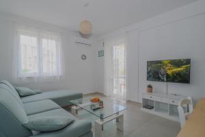 ein weißes Wohnzimmer mit einer Couch und einem Tisch in der Unterkunft Laura Apartments in Brodarica