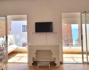a living room with a tv above a fireplace at Dar Amina in Sidi Ifni
