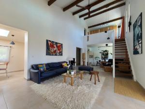 ein Wohnzimmer mit einem blauen Sofa und einem Tisch in der Unterkunft Magnifique villa piscine clim vue dominante 6 couchages in Saint-Clément-de-Rivière