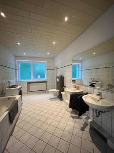 a large bathroom with two sinks and two toilets at Gemütliche Ferienwohnung - voll ausgestattet, zentral aber ruhig ! in Wuppertal