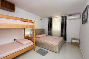 Un dormitorio con dos literas y una ventana. en Guesthouse Berati, en Berat