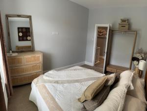 a bedroom with a bed and two mirrors at Four Bedroom High Spec Victorian Townhouse in Clitheroe