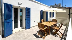 a wooden table and chairs on a balcony with an umbrella at SE100 - Senigallia, nuovo bilocale a 100 mt dal mare in Senigallia