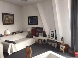 a living room with a white couch in a room at Appartement charmant avec vue sur Tour Eiffel - Paris - 60 m² in Paris
