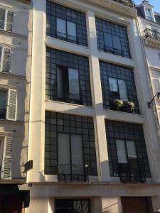 a large building with windows on the side of it at Appartement charmant avec vue sur Tour Eiffel - Paris - 60 m² in Paris