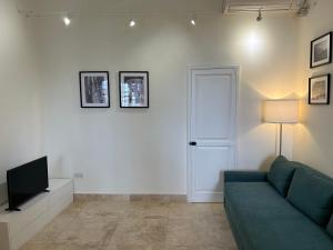 un soggiorno con un divano verde e una televisione di Prestigious Pied a Terre Wignacourt with views a La Valletta