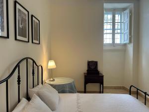 una camera con letto e tavolo con orologio di Prestigious Pied a Terre Wignacourt with views a La Valletta