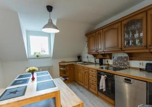 a large kitchen with wooden cabinets and a table at City Apartment Singen in Singen