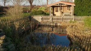 KraksdorfにあるStella Balticaの池の横にある柵のある小さな木造の家 +21枚の写真